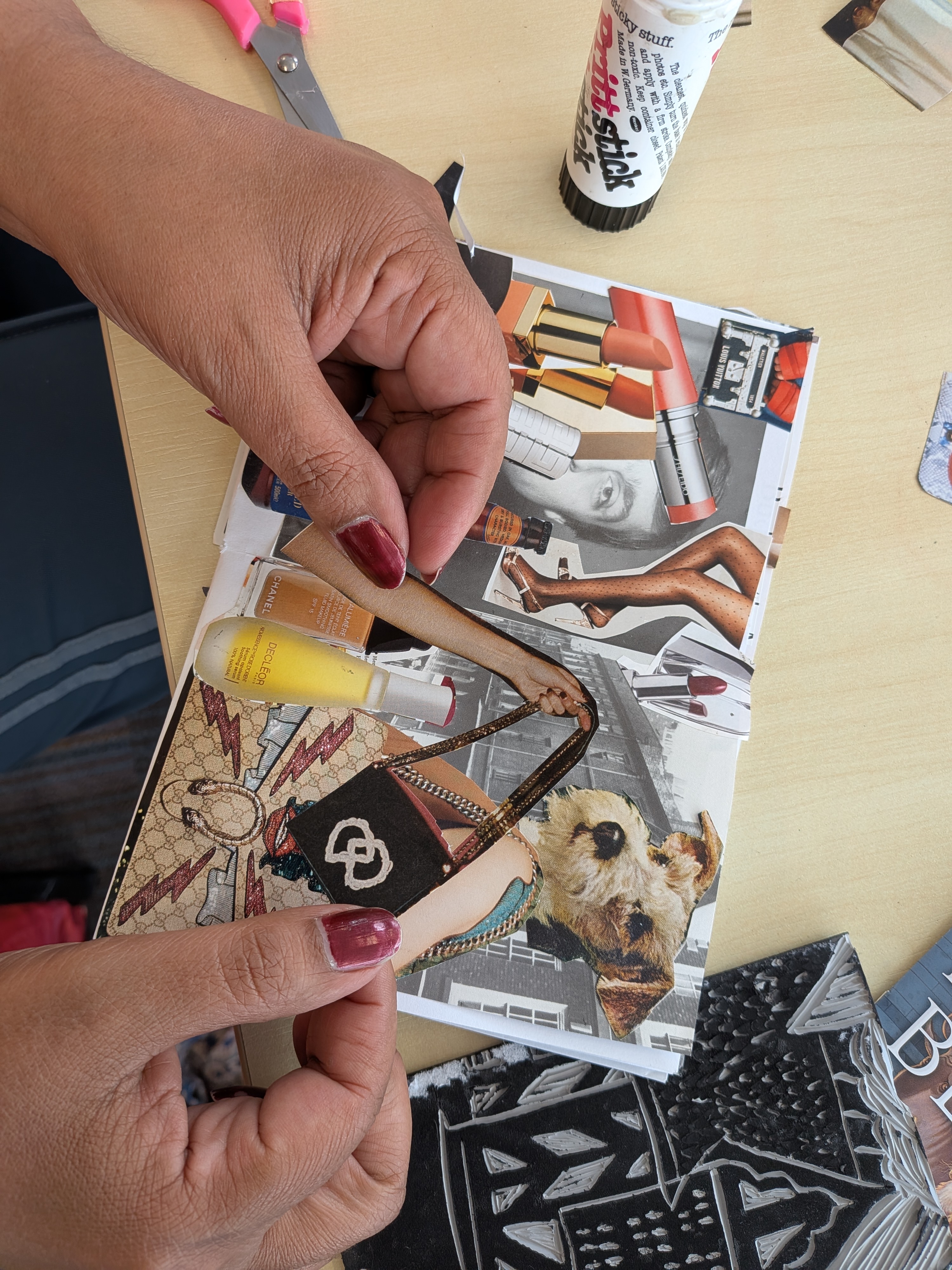 Hands arranging collage material while making a zine